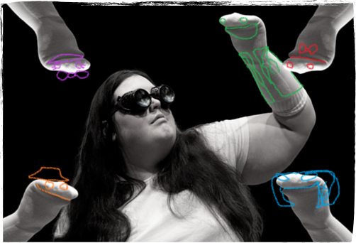 A black and white image of Susan, a fat person wearing steam punk goggles, surronded by hands in socks that have sock puppet faces drawn on over the top of the image