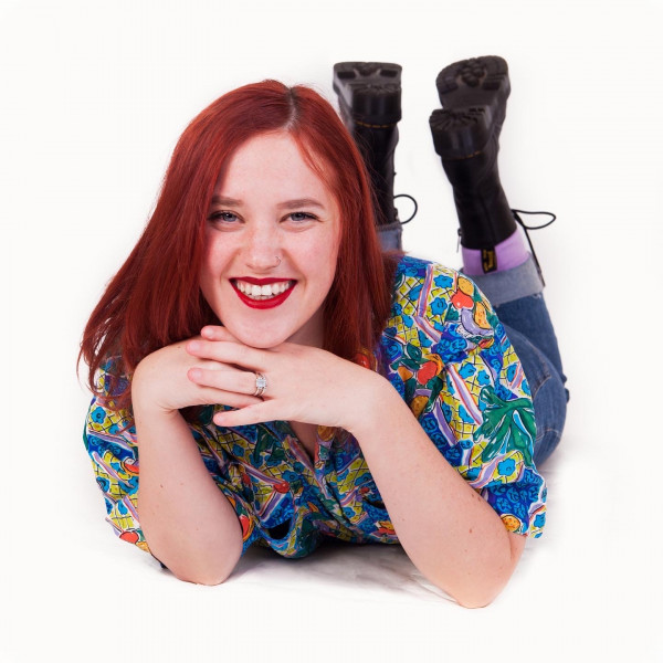 A photo of Sarah Jordan Scott, who is lying on her stomach and smiling