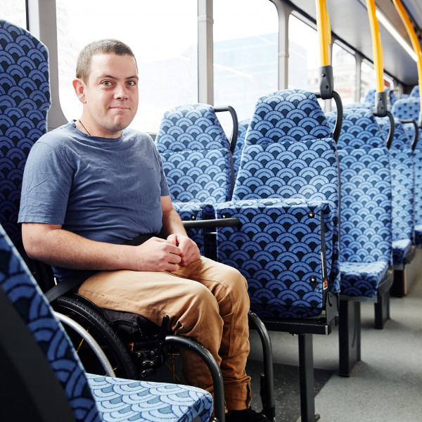 A young man in a wheelchair rides a Waikato bus